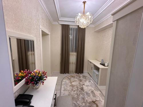 Habitación con baño grande con lámpara de araña y flores. en HAYAT PLAZA HOTEL & Spa, en Samarkand