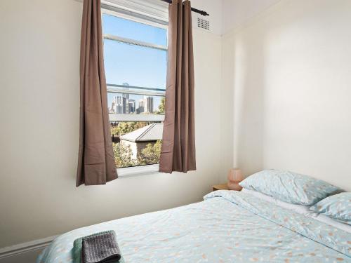 a bedroom with a bed and a window at Lord Wolseley Hotel in Sydney