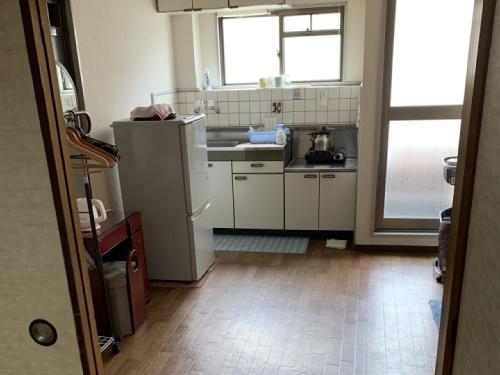 a kitchen with a refrigerator and a sink at Imazato Ryokan in Osaka