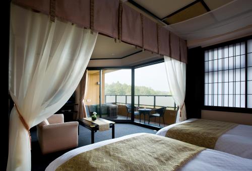 a hotel room with two beds and a large window at Saiou no Miya in Ise