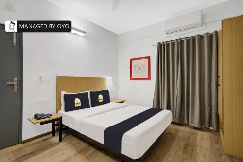 a bedroom with a large bed in a room at Super Townhouse HAL Indiranagar Extension in Bangalore