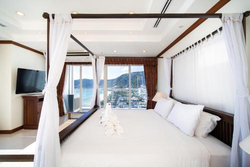 um quarto com uma cama e uma grande janela em Patongtower Duplex Seaview4BR2901 em Patong Beach