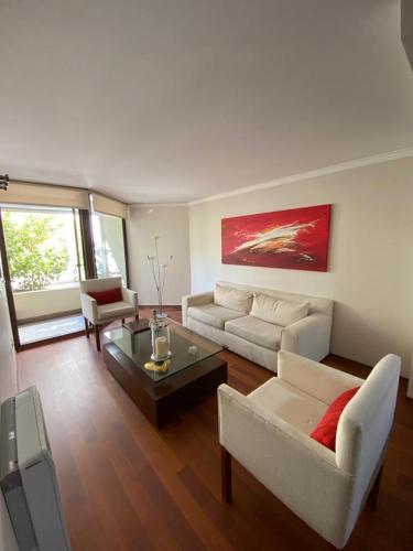 a living room with a couch and a table at Departamento Las Condes Mall Sport in Santiago