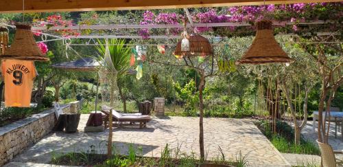 a garden with two hanging baskets and a bench at Guest House Solive in Himare
