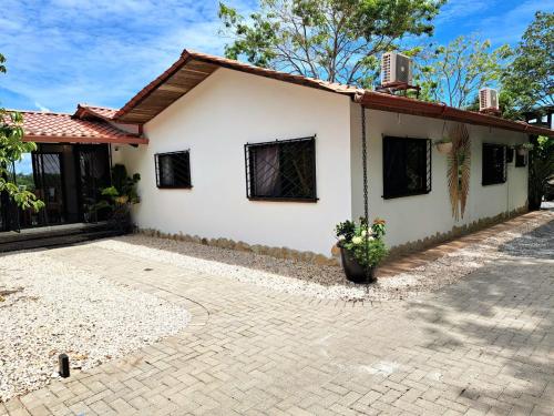 a white house with a brick driveway at Casa Namaste del Pacifico - Luxury Villa in Santa Teresa Beach