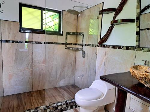 a bathroom with a toilet and a sink at Casa Namaste del Pacifico - Luxury Villa in Santa Teresa Beach