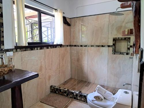 a bathroom with a toilet and a shower at Casa Namaste del Pacifico - Luxury Villa in Santa Teresa Beach