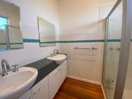 a bathroom with two sinks and a shower at Cosy retreat beach house in Rye