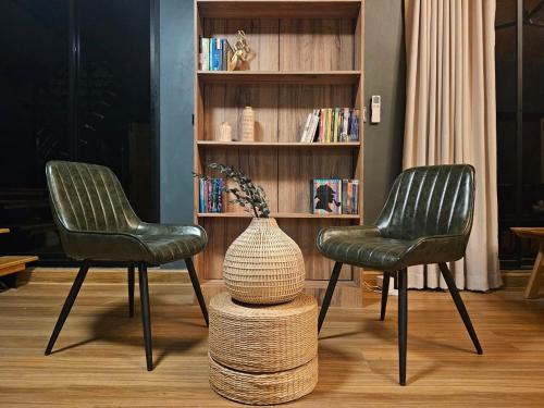 two chairs and a vase on a stool in a room at Take Time Nature Resort in Ban Tha Sai