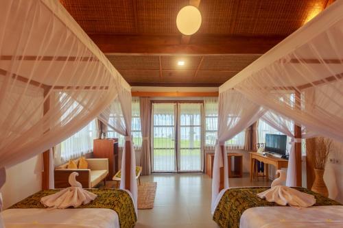 a bedroom with two beds and a living room at Villa So Long Banyuwangi - Ijen in Banyuwangi
