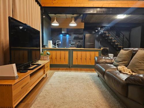 a living room with a couch and a large television at Take Time Nature Resort in Ban Tha Sai