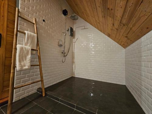 a bathroom with a shower in a white brick wall at Take Time Nature Resort in Ban Tha Sai