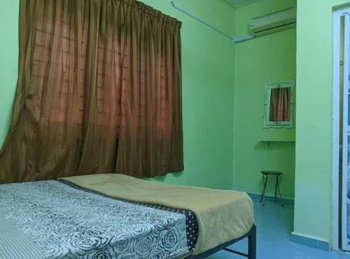 a bedroom with a bed and a window with a curtain at Homestay sunnah bougainvillea resident Islam 