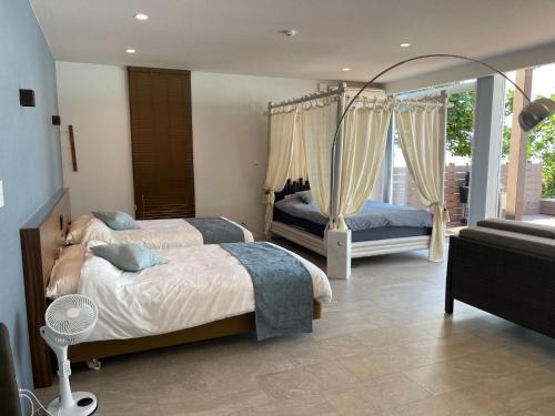 a bedroom with two beds and a balcony at Premium Villa Miyagijima - Vacation STAY 06499v in Uruma