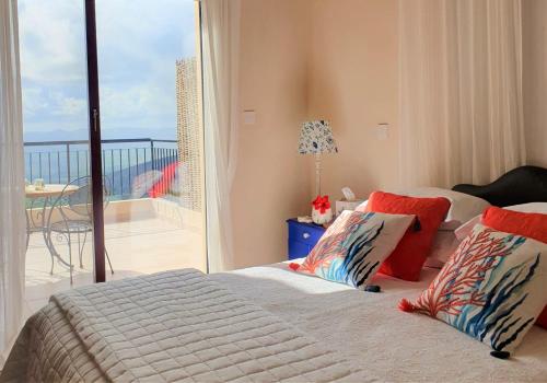 1 dormitorio con 1 cama y vistas a un balcón en Ithaki House, en Lyso