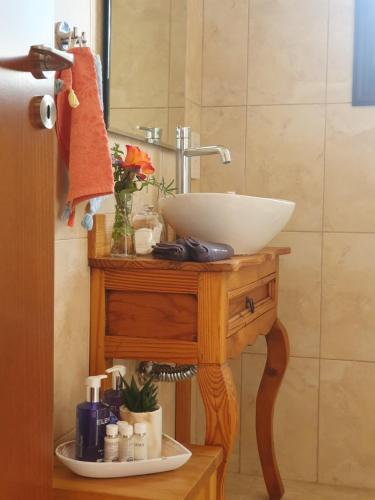 een badkamer met een wastafel op een houten tafel bij Ithaki House in Lyso