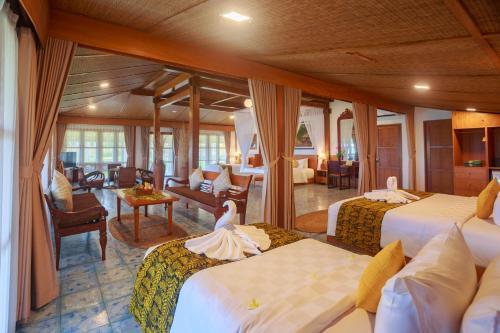 a hotel room with two beds and a living room at Villa So Long Banyuwangi - Ijen in Banyuwangi