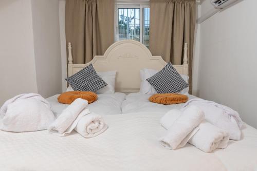a white bed with towels and pillows on it at Moses Luxury Vacation Homes הבית בכ"ה in Safed
