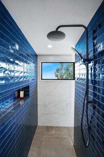 a bathroom with blue tiled walls and a shower at Maleny Country Estate in Maleny