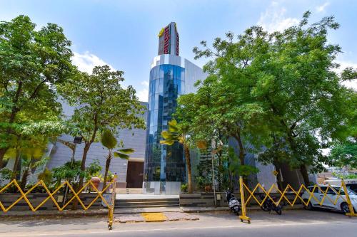 um edifício de vidro alto com um sinal nele em FabHotel GL Residency em Ahmedabad
