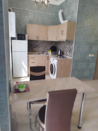 a kitchen with a table and chairs and a refrigerator at Отличная квартира в центре Ванадзора in Vanadzor