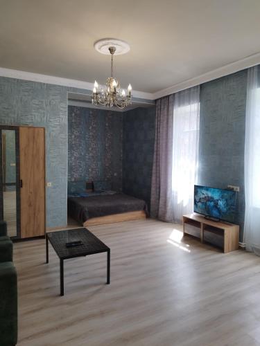 a living room with a bed and a table at Отличная квартира в центре Ванадзора in Vanadzor