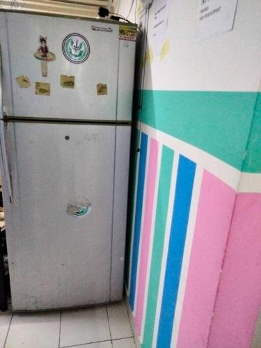 een kleurrijke koelkast in een keuken naast een muur bij Sharaf DG Metro Unisex PARTITION Private room -40-02 in Dubai