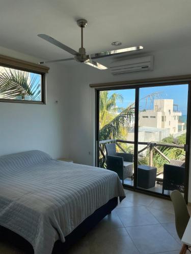 a bedroom with a bed and a large window at Departamento El Cardumen in Chicxulub