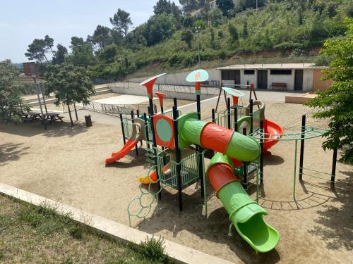 un parque infantil con tobogán en Casita rural con piscina en La Torre de Claramunt