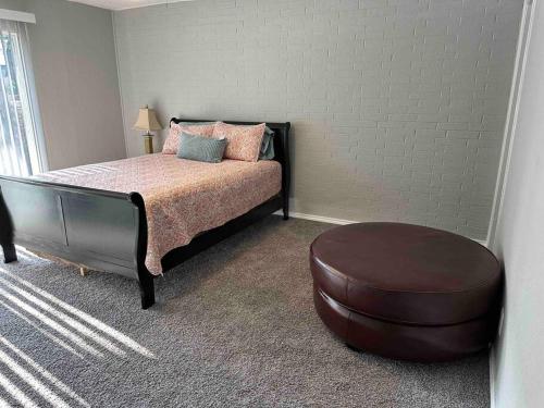 a bedroom with a bed and a ottoman at Right next to AT&T Stadium Arlington - Luxury Unit in Arlington