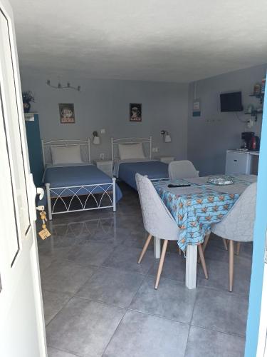 a room with two beds and a table and chairs at Castle By The Sea in Artemida