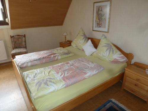 Un dormitorio con dos camas y una silla. en Ferienwohnungen Eckstein, en Bernkastel-Kues