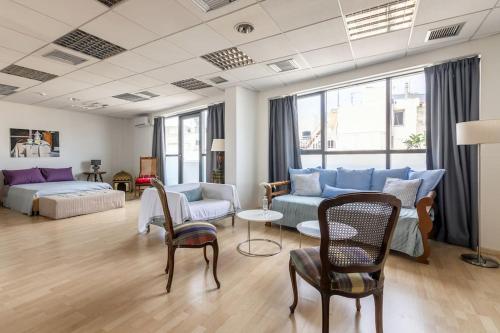 a living room with a couch and a table and chairs at Downtown Spacious Loft Apartment just 3 minutes from City Centre in Heraklio Town