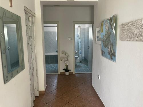 - un couloir dans une salle de bains pourvue d'une douche et d'une baignoire dans l'établissement Apartment Juric NeVi, à Malinska