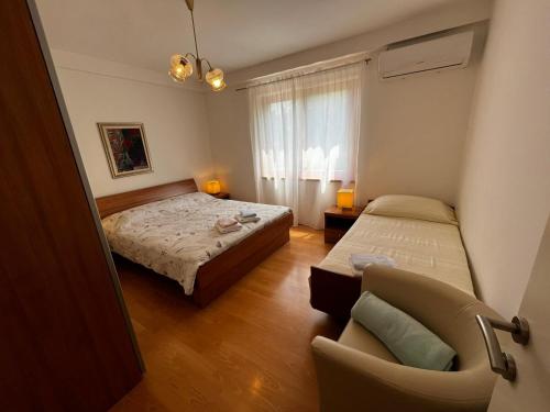 - une petite chambre avec 2 lits et une chaise dans l'établissement Apartment Juric NeVi, à Malinska