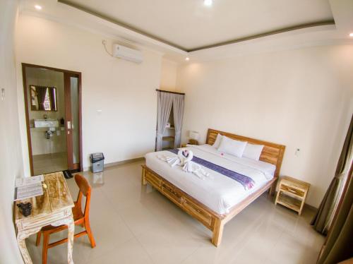 a bedroom with a bed and a table and a chair at The Lucky Canggu in Canggu