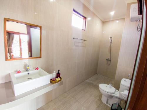 a bathroom with a tub and a toilet and a sink at The Lucky Canggu in Canggu