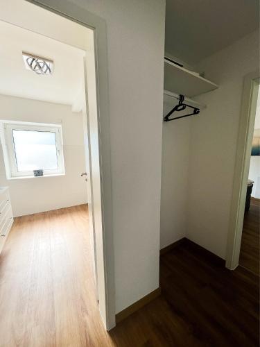 an empty room with a window and wooden floors at Modern Apartment Wissenbach 2 barrierefrei in Eschenburg