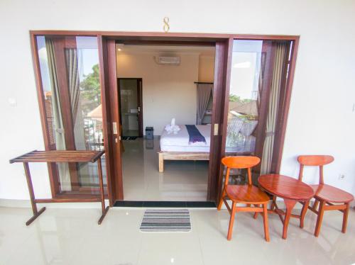 a room with two chairs and a table and a bed at The Lucky Canggu in Canggu