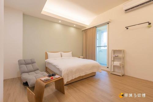 a bedroom with a bed and a chair and a table at Muguang Elevator Homestay in Wa-li-t'a-she