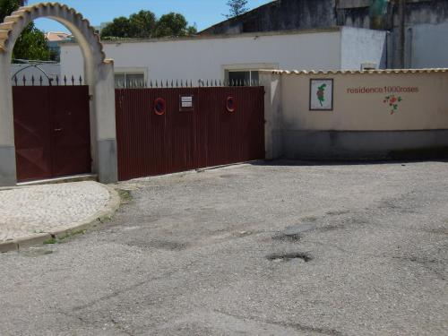 a building with a red fence and a gate at Residence 1000 Roses in Moncarapacho
