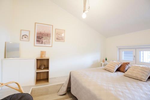 a white bedroom with a bed and a window at Hilmantori Apartments by Hiekka Booking in Kalajoki