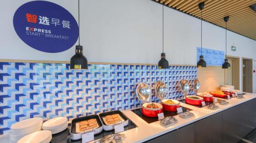 a buffet line with plates and bowls of food at Holiday Inn Express Shanghai Pudong Airport by IHG in Shanghai