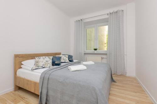 1 dormitorio blanco con 1 cama con 2 toallas en Bright Apartment Wola near Metro Station by Renters, en Varsovia