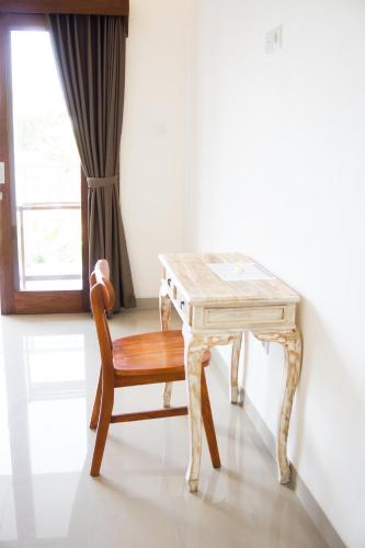 a wooden table with a wooden chair and a desk at The Lucky Canggu in Canggu