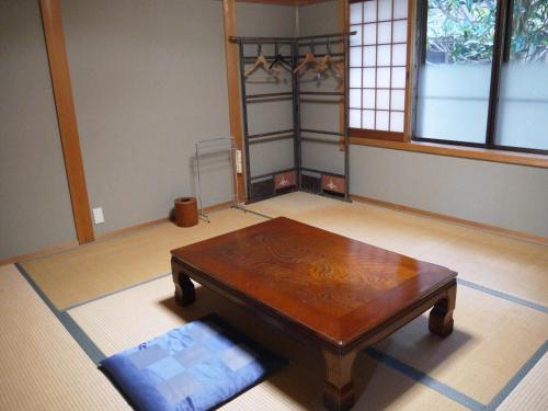 salon z drewnianym stołem i oknem w obiekcie 宿坊　光明院 w mieście Kōya-san