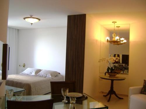 a hotel room with a bed and a table and a room at Boa Viagem 420 Apart Hotel in Recife