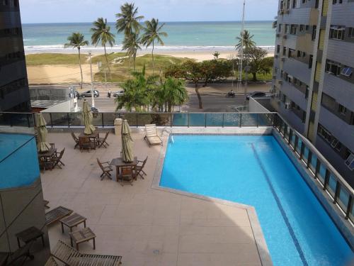 desde el balcón de un hotel con vistas a la piscina y a la playa en Boa Viagem 420 Apart Hotel en Recife