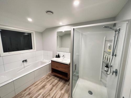 a bathroom with a tub and a sink and a shower at Lovely Family Home in Aotea with Grear Views - No Parties or Smoking in Porirua