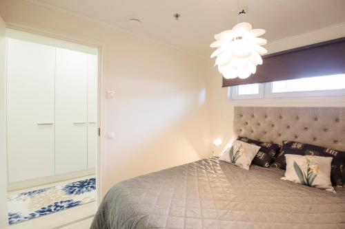 a bedroom with a large bed and a chandelier at Hilmantori Apartments by Hiekka Booking in Kalajoki